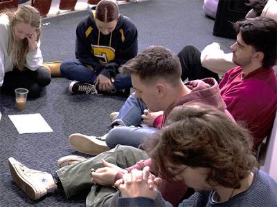 With a list of prayer requests from fellow students before them, a circle of students gathered in the front of Shortess Chapel. (Photo by Jonathan McGaha, CIU Student Photographer) 